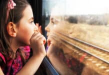 Aumento del Transporte Ferroviario de Pasajeros en un 5.8% en 2024 A girl looking out of a train window.