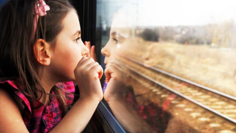 A girl looking out of a train window.