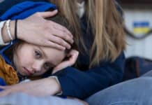 Las decisiones de protección temporal alcanzan su nivel más alto en dos años child nestled on someone