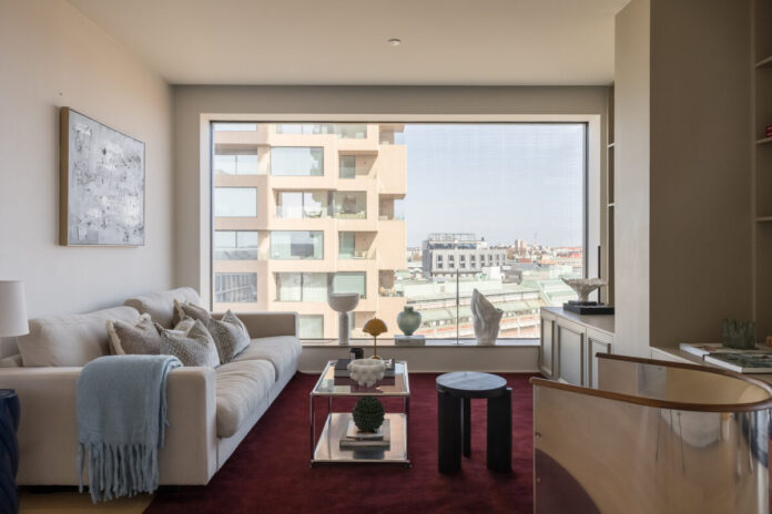 Alfombra Burdeos: Toque de Color en un Salón de Estilo Sofá crema sobre alfombra burdeos en apartamento escandinavo contemporáneo