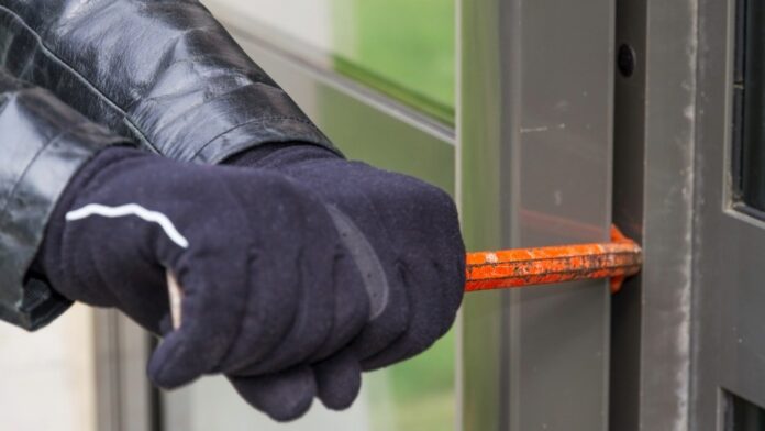 Los robos en viviendas en la UE se reducen un person wearing gloves and forcing a door to open