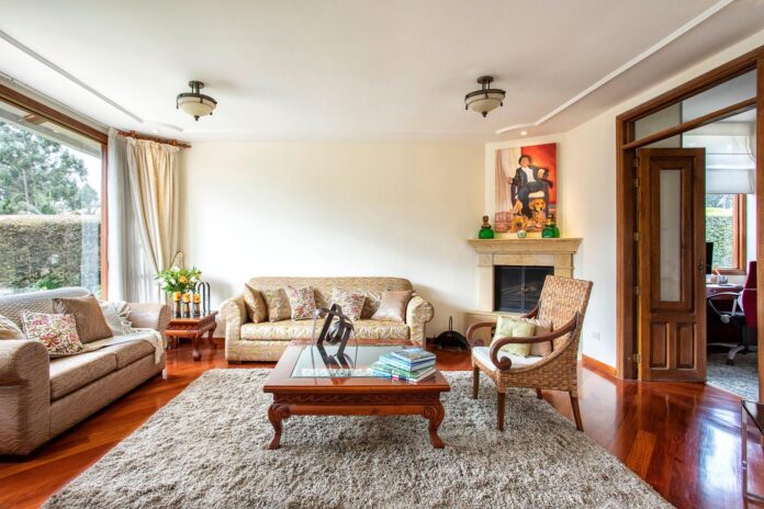 Convierte Tu Casa en un Hogar Acogedor: Guía Completa Salón elegante y acogedor con muebles clásicos, iluminación cálida y una alfombra beige de pelo largo que define la zona de descanso.