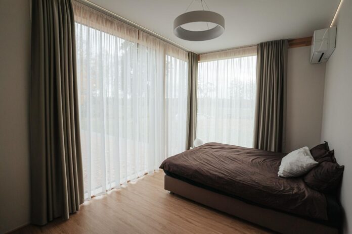 Guía Definitiva para Seleccionar las Cortinas Perfectas para Tu Dormitorio Dormitorio moderno con visillos blancos que permiten la entrada de luz natural, creando un ambiente luminoso y fresco.